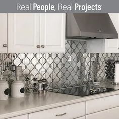 a kitchen with white cabinets and stainless steel backsplashes on the counter top