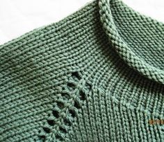 a green knitted sweater with holes in the middle