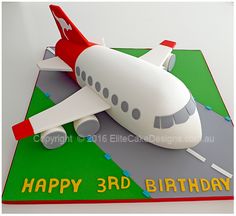 a birthday cake shaped like an airplane on the ground