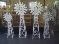 three white windmills sitting on top of a floor