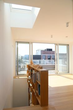 an empty room with bookshelves, windows and a skylight in the corner