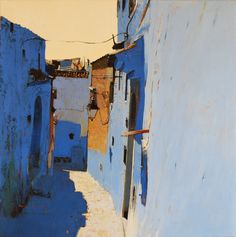 an alley way with blue buildings and no one on it in the day light,