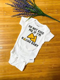 a baby bodysuit that says, do not kiss me if i'm nacho baby