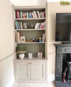 a living room with a fireplace and bookshelf next to a flat screen tv