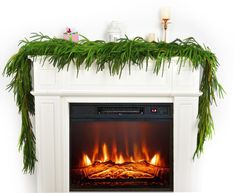 a christmas fireplace decorated with pine branches and garland on the mantel above it is an electric fire