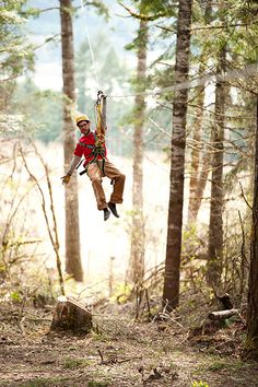 a man in the air while zipping through the woods