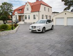 a white car parked in front of a house