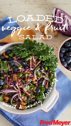 a white bowl filled with salad next to blueberries and broccoli