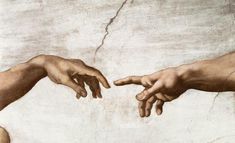 two hands touching each other in front of a painting