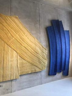 two pieces of wood sitting on top of a wall next to blue and yellow strips