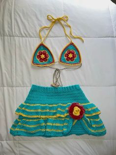 two crocheted swimsuits are hanging on a bed