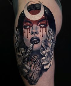 a woman's face with blood dripping from her eyes and flowers on her thigh