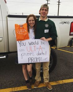 a man and woman standing next to each other holding a sign that says you would be the ultra date prom