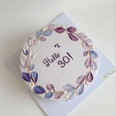 a birthday cake decorated with purple leaves and the number forty five on it's side