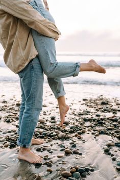 a person standing on top of a beach next to the ocean with their feet in the sand