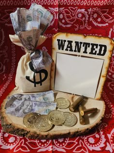 a bag full of money sitting on top of a table next to a sign that says wanted