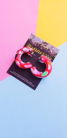 a pair of red and pink bracelets on top of a blue and yellow background