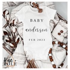 a white baby onesuit with the words, baby andersonn on it next to some