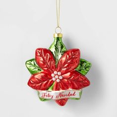 a glass ornament with a poinsettia decoration on the front and side