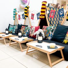 a room filled with lots of different types of pillows on top of wooden tables next to each other