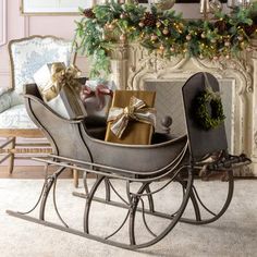 a sleigh filled with presents sitting in front of a fireplace