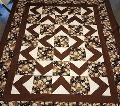 a brown and white quilt on top of a bed