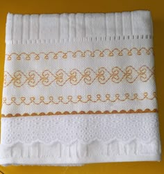 two white towels are sitting on a yellow surface