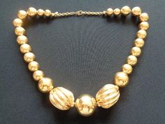 "This is a Lovely Classic Vintage From the 70's -80's Signed MONET Jewelry Melon Shaped and Ball Beads Shiny Gold Tone Metal Collar Necklace Perfect For Mothers Day Gifts The necklace measures approx: 18\" long and the largest bead is 1\" by 7/8 wide/thick. This beautiful necklace is in very good vintage condition very clean and ready to wear! For more fabulous MONET NAPIER & TRIFARI vintage jewelry and accessories including other bangles bracelets please see our \"Vintage TRIFARI NAPIER MON Retro Gold Necklaces With Round Beads, Retro Gold Necklace With Round Beads, Retro Gold Beaded Necklaces For Gifts, Retro Gold Beaded Necklace For Gift, Monet Jewelry, Vintage Trifari, Gold Chain Jewelry, Vintage Monet, Monogram Design