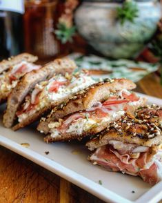 two sandwiches with meat and cheese on a white plate