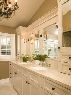 a bathroom with double sinks and two mirrors on the wall above them is decorated in white