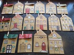 paper houses with clothes pins attached to them sitting on a black table next to other pieces of cardboard