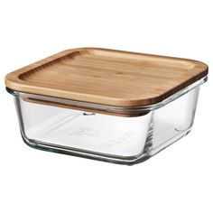 a glass casserole with a wooden cutting board in the bottom and lid on top