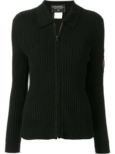 The perfect middle ground between a polo shirt and a jacket, this soft cashmere offering from Chanel is your new weekend companion. Deep vertical ribs punctuated the ebony black backdrop, while a logo patch to the sleeve is embellished with shimmering beads. Featuring a spread collar, a front zip fastening, a ribbed design, long sleeves and an embellished logo patch to the arm. Please be mindful that this piece has led a previous life, and may tell its story through minor imperfection. Purchasin Chanel Shirt, Chanel Outfit, Dolce E Gabbana, Black Cardigan, Zip Up, Miu Miu, Black Shirt, Prada