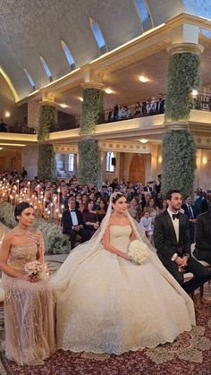 the bride and groom are sitting in front of an audience at their wedding ceremony, surrounded by candles