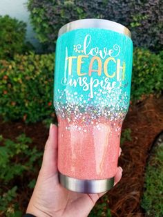 someone holding up a cup with glitter on it that says i love teach and inspire