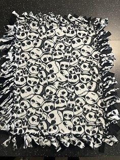 a pile of skulls sitting on top of a black and white tablecloth covered in paper