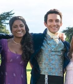 three people standing next to each other in formal wear and smiling at the camera with trees in the background