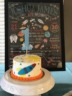 a birthday cake on a table with a chalkboard in the background