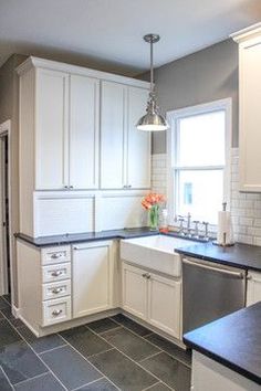 a kitchen with white cabinets and black counter tops