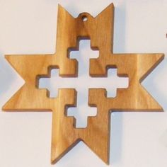 a wooden star ornament with four crosses in the center on a white background