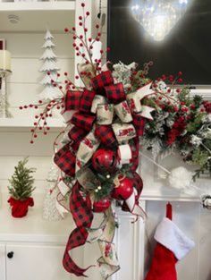 a christmas wreath hanging from the side of a fireplace with stockings and decorations around it