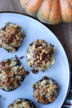 several muffins on a white plate next to mini pumpkins