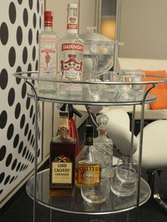 a bar cart with liquor bottles and glasses on it