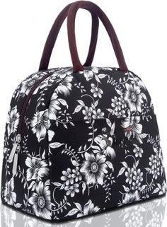 a black and white flowered bag with brown leather handles on the front, side view