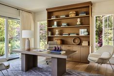 a living room filled with furniture and a book shelf on top of a wooden table