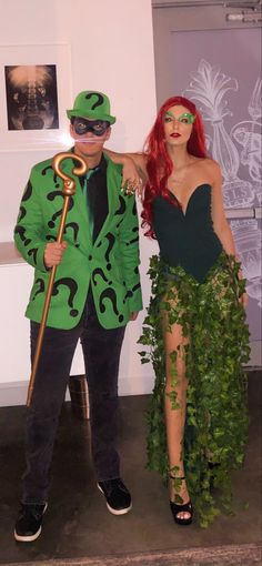 a man and woman dressed up as riddle and the girl in green is standing next to each other