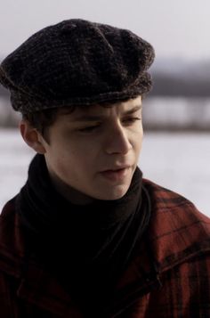 a young man wearing a hat and scarf