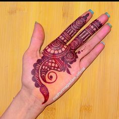 a woman's hand with henna tattoos on it