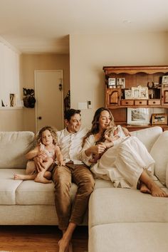 a man and woman sitting on a couch with two children