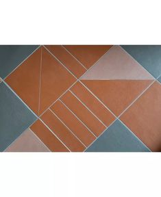 an orange and blue tiled floor with white lines on the bottom, and grey tiles below